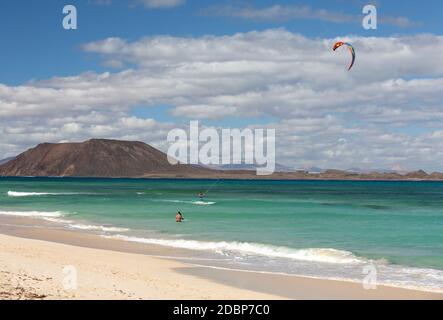 Unbekannt Kitesurfer Surfen auf einem flachen azurblauen Wasser des Atlantiks in Corralejo, Fuerteventura, Kanarische Inseln, Spanien Stockfoto