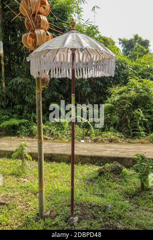 Dekoration des Hindu-Tempelkomplexes Batukaru auf Bali in Indonesien. Gelb-weiße dekorative Schirme säumen den Weg für gläubige Besucher. C Stockfoto