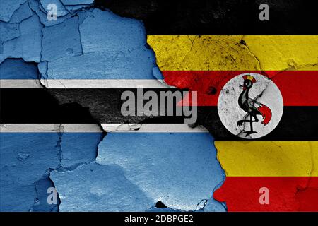 Flagge von Botswana und Uganda auf gerissene Wand gemalt Stockfoto