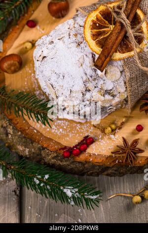 Weihnachtsfeiertage Hintergrund. Stollen, deutscher Weihnachtskuchen mit getrockneten Früchten und Mandelnüssen in Scheiben Stockfoto