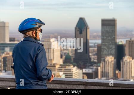 Montreal, CA - 10 November 2020 : Mann trägt eine Maske inmitten Coronavirus Ausbruch Blick auf Montreal Skyline von der Spitze des Mount Royal Stockfoto