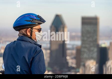 Montreal, CA - 10 November 2020 : Mann trägt eine Maske inmitten Coronavirus Ausbruch Blick auf Montreal Skyline von der Spitze des Mount Royal Stockfoto