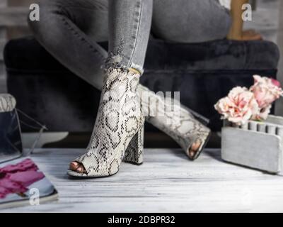 Luxus Damen hohe Absatz Schuhe aus Schlangenhaut von einer Frau getragen Stockfoto