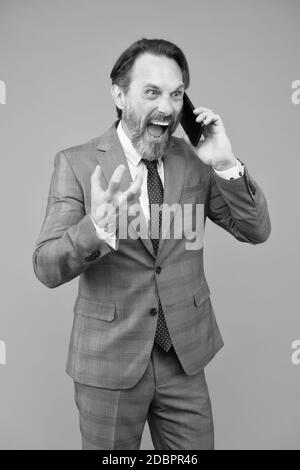 Schlechte Nachrichten. Wütend ceo schreit auf Kollegen. ceo in Büro Jacke sprechen auf Smartphone. Reife Geschäftsmann Antwort E-Mail. Professionelle Business-Mann in formellen Anzug. Zuversichtlich, männlichen Nutzung Mobiltelefon. Stockfoto