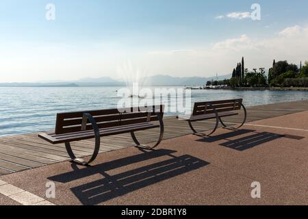 Leere Bänke am Gardasee, Bardolino, Italien Stockfoto