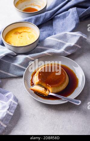 Pudding Creme Karamell Flan Dessert Ofen gekocht. Hausgemachte Milch und Ei Dessert mit karamellisierten Zuckersoße auf steingrauem Hintergrund Stockfoto