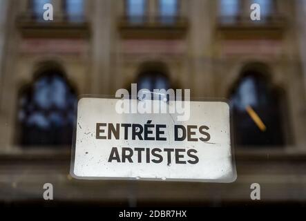 Bukarest, Rumänien - 11. November 2020 EIN schönes Gebäude verschwommen reflektiert auf einem Schaufenster mit der Ansage "Entree des artistes", in downto Stockfoto