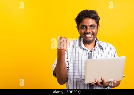 Nahaufnahme Asian glücklich Porträt junge schwarze Mann aufgeregt halten Laptop-Computer Festhalten Fäuste und eine Hand für Sieger Zeichen feiert seinen Erfolg Stockfoto