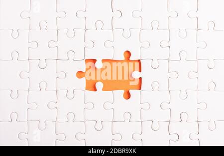 Draufsicht flache Lage Papier schlicht weiß Puzzle-Spiel Textur unvollständig oder fehlende Stück, Studio auf einem orangen Hintergrund geschossen, Quiz-Berechnung c Stockfoto