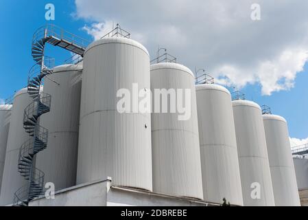 Reihen von Brühtanks gegen den Himmel. Industrielle Bierherstellung Stockfoto