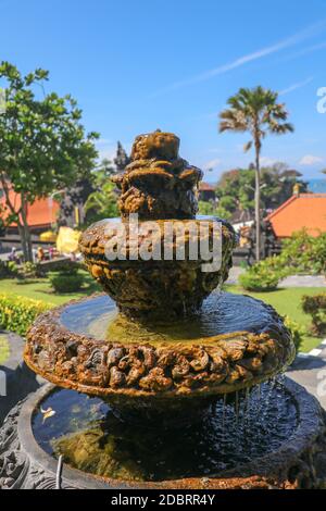 Friedliche Landschaft mit Brunnen. Park in der Nähe des Hindu-Tempels Tanah Lot, Bali, Indonesien. Kleiner dekorativer Brunnen im tropischen Garten für Landschafts desi Stockfoto