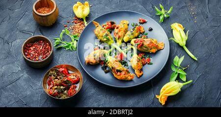 Köstliche gebratene Zucchini Blumen gefüllt mit sonnengetrockneten Tomaten.Sommer Essen. Stockfoto