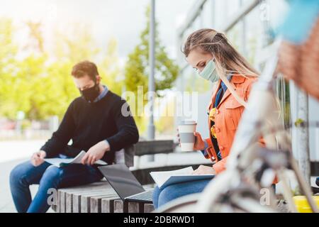Zwei Studenten lernen, während soziale Distanz auf dem Campus zu halten Stockfoto
