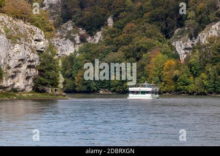 Passagierschiff, die Donau Durchbruch in der Nähe von Kelheim, Bayern, Deutschland im Herbst mit Kies bank im Vordergrund und Kalksteinformationen in der Bac Stockfoto