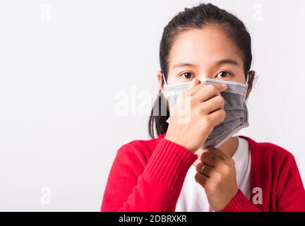 Nahaufnahme des Porträts asiatische Erwachsene Frau trägt rotes Hemd und Gesichtsmaske Schutz gegen Coronavirus oder COVID-19 Virus zeigt korrekte s Stockfoto