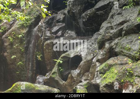 Die Erosion schuf ein Loch in Form eines Herzens im Felsen. Eine herzförmige Lücke im Stein eines Flussbettes in Bali, Indonesien. Stockfoto