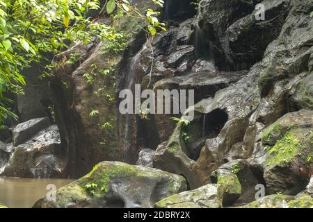 Die Erosion schuf ein Loch in Form eines Herzens im Felsen. Eine herzförmige Lücke im Stein eines Flussbettes in Bali, Indonesien. Stockfoto