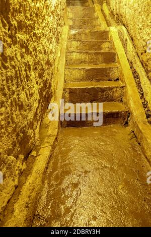 Zugang Treppe zu einer Höhle. Treppe in einem handgeschnitzten Tunnel in den Fels. Steintreppen zur U-Bahn auf der Insel Bali, Insdonesia. Unterirdische Steppe Stockfoto
