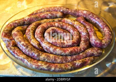 Hausgemachte Würstchen auf Kartoffeln zum Kochen vorbereitet. Traditionelle europäische Küche. Stockfoto