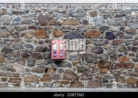 Kaugummi Maschine hängt an einer Ziegelwand Fassade Stockfoto