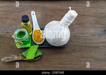 Spa Kräuter (Kurkuma Pulver in weißen Löffel, Aloe Vera ätherisches Öl und Gel ) auf Holzhintergrund Stockfoto