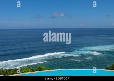 Luxuriöser Infinity-Pool mit Meerblick und Palmen. Bali, Indonesien. Stockfoto