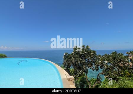 Luxuriöser Infinity-Pool mit Meerblick und Palmen. Bali, Indonesien. Stockfoto