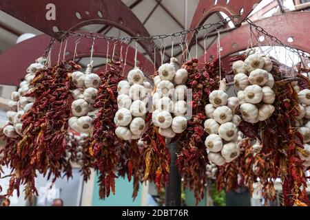 Chilischoten und Knoblauch an Schnur in Funchal auf Madeira. Portugal Stockfoto