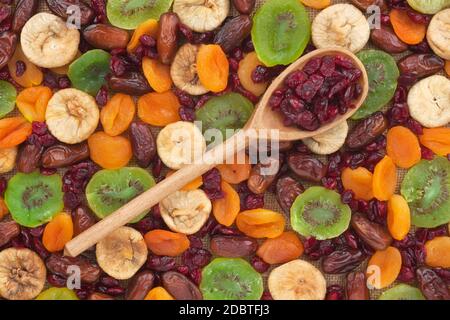 Holzlöffel mit Preiselbeeren, auf dem Hintergrund der Früchte Stockfoto