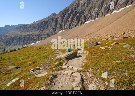 Wanderer entspannen auf einem Bergpfad in der Nähe von Hidden Lake in Glacier National Park in Montana Stockfoto