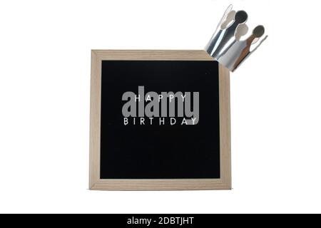 Ein Schild mit Birke-Rahmen, das Happy Birthday in weißen Buchstaben mit einer silbernen Krone auf einem rein weißen Hintergrund sagt Stockfoto