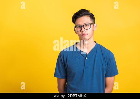 Kopfschuss Porträt von asiatischen jungen schönen Mann tragen Brillen oder Brillen, Studio kurz isoliert auf gelbem Hintergrund mit Kopieplatz, Mode männlich Stockfoto