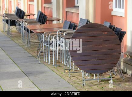 Potsdam, Deutschland. November 2020. Tische und Stühle der Genusswerkstatt im Filmmuseum werden mittags zusammengeschoben und mit Drahtseilen gesichert. Wegen der Corona-Bars mussten die gastronomischen Einrichtungen geschlossen und wieder auf den Lieferservice umgestellt werden. Quelle: Soeren Stache/dpa-Zentralbild/ZB/dpa/Alamy Live News Stockfoto