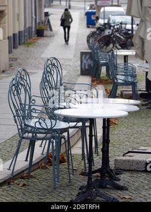 Potsdam, Deutschland. November 2020. Tische und Stühle eines Cafés in der Humboldtstraße werden mittags zusammengeschoben und mit Drahtseilen gesichert. Wegen der Corona-Bars mussten die gastronomischen Betriebe des Landes schließen und auf den Lieferservice umstellen. Quelle: Soeren Stache/dpa-Zentralbild/ZB/dpa/Alamy Live News Stockfoto