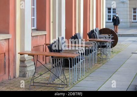 Potsdam, Deutschland. November 2020. Tische und Stühle der Genusswerkstatt im Filmmuseum werden mittags zusammengeschoben und mit Drahtseilen gesichert. Wegen der Corona-Bars mussten die gastronomischen Einrichtungen geschlossen und wieder auf den Lieferservice umgestellt werden. Quelle: Soeren Stache/dpa-Zentralbild/ZB/dpa/Alamy Live News Stockfoto