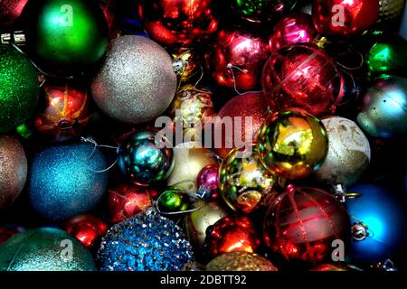 Draufsicht auf Haufen von dunklen und bunten Weihnachtskugeln für eine abstrakte Weihnachtszeit Hintergrund Muster. Stockfoto