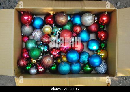 Draufsicht auf bunte Weihnachtskugeln in einem offenen Karton. Stockfoto