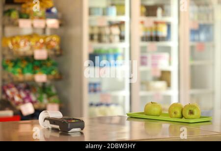 Eine Schulkantine, Tuck-Shop oder Café, das gesunde Fruchtgerichte anbietet. Chips und Getränke auf dem Display im Hintergrund. Elektronisches Zahlungsterminal Stockfoto