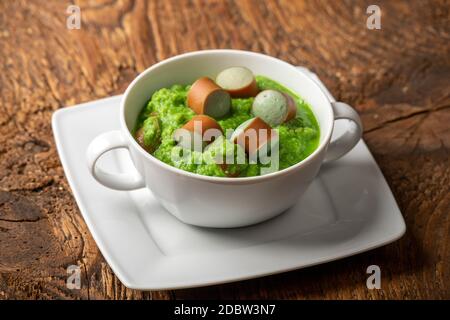 Cremige Erbsensuppe auf dunklem Holz Stockfoto