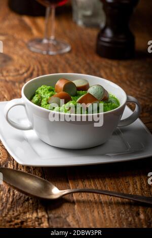 Cremige Erbsensuppe auf dunklem Holz Stockfoto