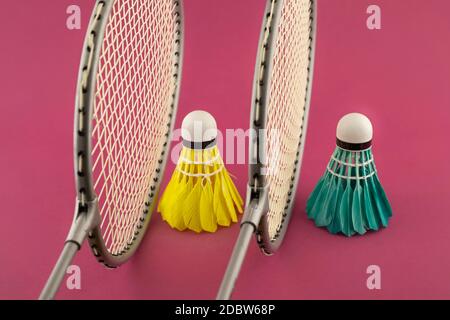 Badminton Schläger und bunt gefiederte Schuttlecken in Blau und Gelb auf Punk-Hintergrund Stockfoto