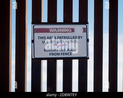 Warnschild an der USA und Mexiko Grenzmauer mit Trump-Aufkleber Stockfoto