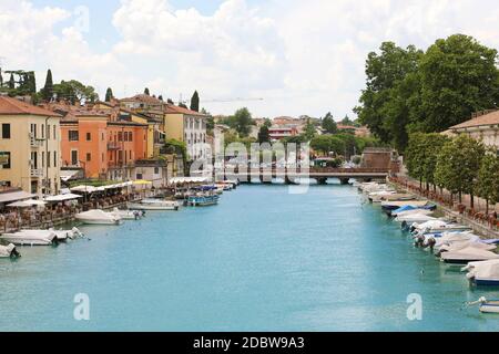 PESCHIERA DEL GARDA, ITALIEN - 9. JUNI 2020: Schöne historische Innenstadt mit Promenade und Unterhaltung entlang des Wasserkanals am Gardasee, Ital Stockfoto