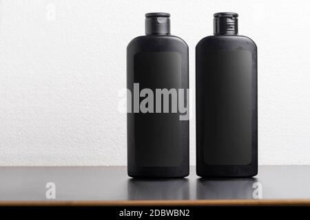 Schwarze Haar Shampoo-Flaschen vor hellgrauem Hintergrund, bearbeitbare Modell-up-Serie Vorlage bereit für Ihr Design, Auswahlpfad enthalten. Stockfoto