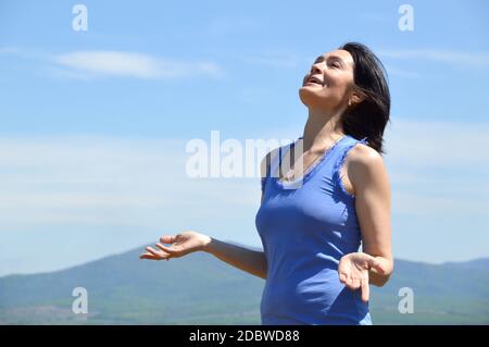 Junge Brünette Frau mit dem Kopf zum Himmel angehoben lächelnd mit Zitze und genießen Freiheit. Sonnigen Sommertag Stockfoto