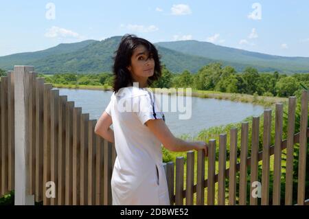 Porträt der 45-jährigen russischen Brünette Frau wandte sich zurück und Blick auf die Kamera. Windiger Sommertag in der Nähe des Sees Stockfoto