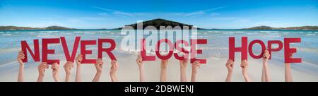 Menschen Hände Halten Bunte Englisch Wort Verlieren Nie Die Hoffnung. Meer Und Strand Als Hintergrund Stockfoto