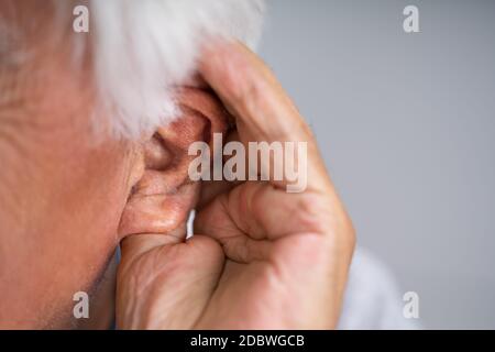 Hörgeräteproblem. Alter Mann Versucht Zu Hören Stockfoto