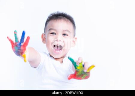 Portrait von asiatischen glücklich kleinen Baby Junge glücklich Gesicht zeigen Hand hat er Aquarell oder Fingerfarbe auf Händen die Fotografie im Studio auf mit backgrou Stockfoto