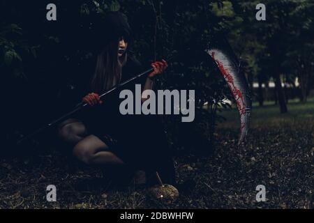 Porträt von Frau Teufel Geist Dämon Kostüm Horror halten gruselig oder Reaper auf der Hand, Happy Halloween Tag Konzept Stockfoto